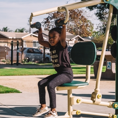 Young child playing on exercises machines after the completion of Jacaranda Park