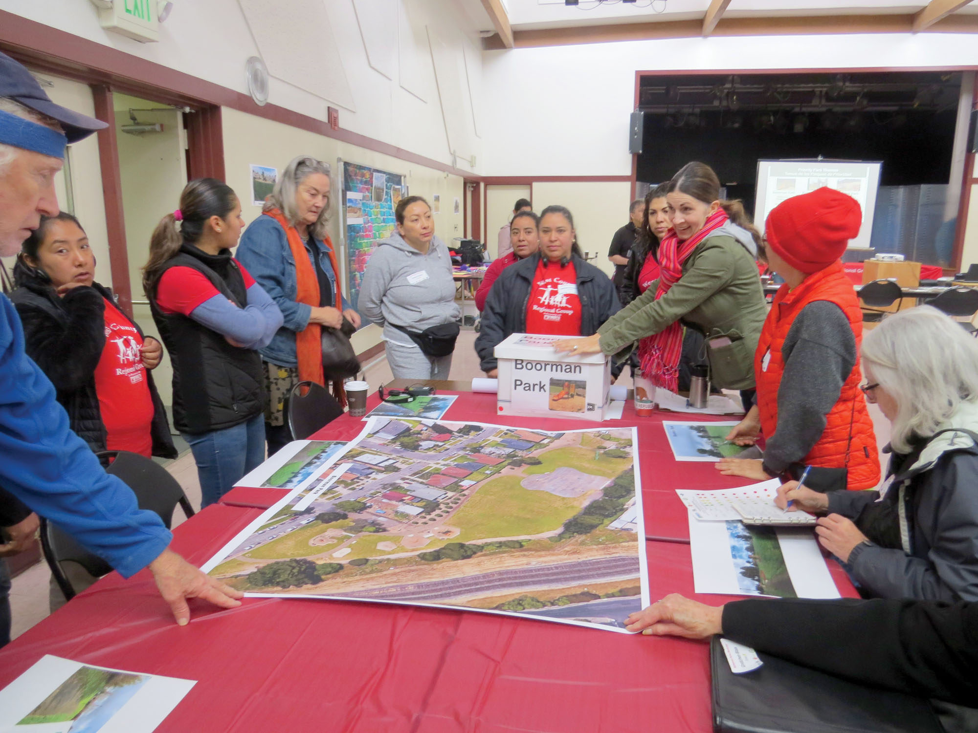 People standing arounda table reviewing and discussing a large printed aerial photograph map