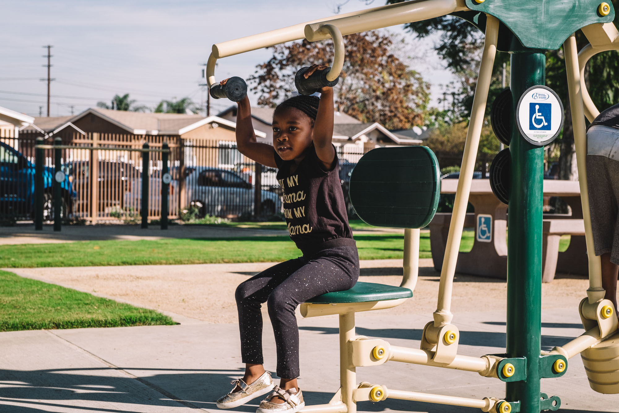 A child uses exercise equipment outdoors in a park